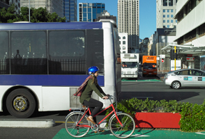 A bike riding past a bus in the city