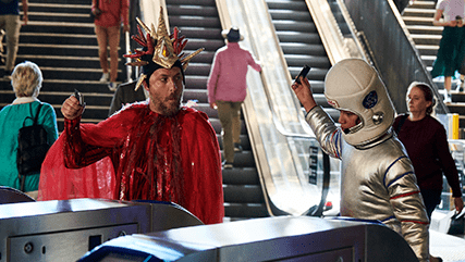People in fancy dress going through security gates at train station