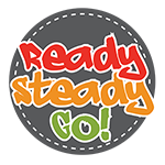 A grey circle with the words ready steady go in red orange and green text. There are dotted white lines around the outside of the grey circle
