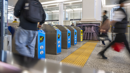 Customers walking past ticket barriers in a train station