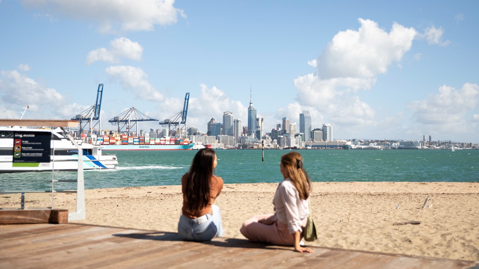 Two women looking at the city from the beach in Devonport.